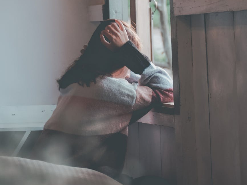 photo of a person leaning on wooden window
